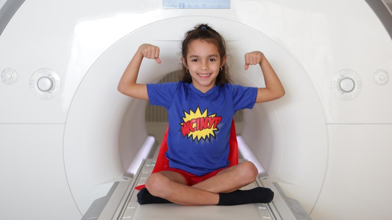 image of child wearing superhero cape getting an MRI