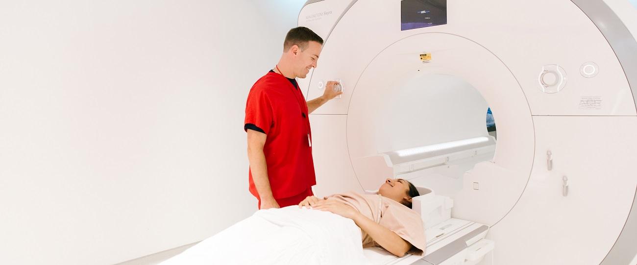 a technician is talking to a patient who is lying down for MRI